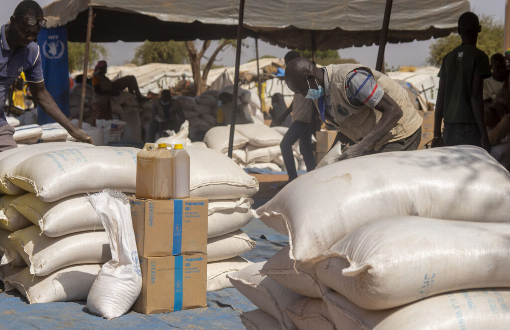 Gli agenti di distribuzione alimentare di uno dei partner cooperanti del Wfp immagazzinano sacchi di cereali e scatole di olio vegetale su un telone in attesa dei beneficiari.