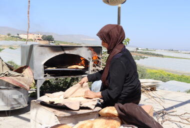 Palestina, donna cucina pane in un forno