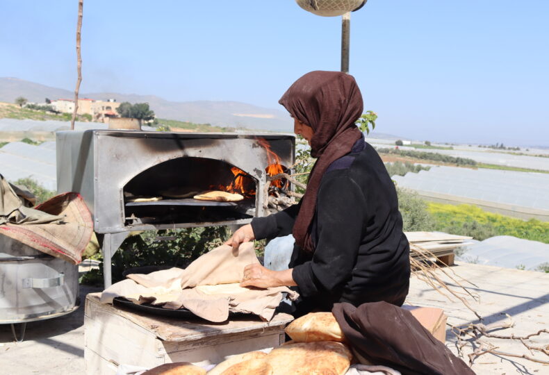 Palestina, donna cucina pane in un forno