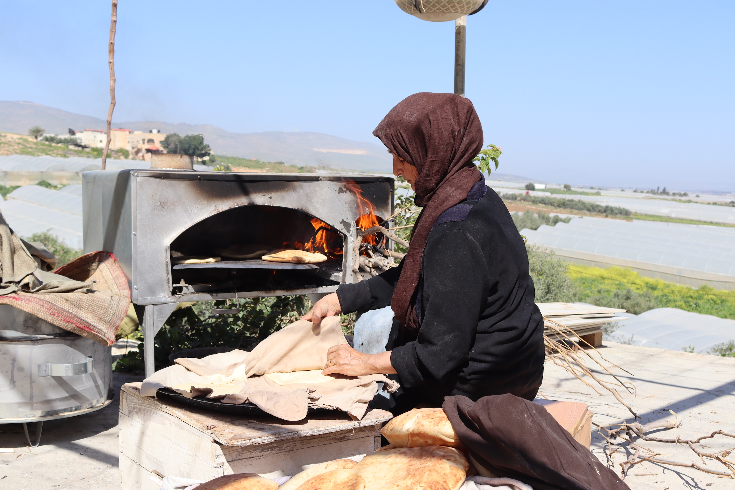 Palestina, donna cucina pane in un forno